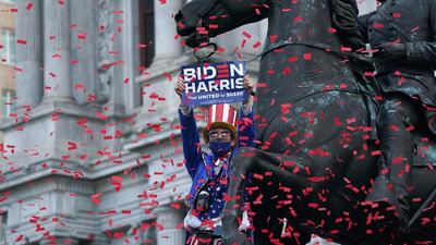 A man dressed as Uncle Sam celebrates while standing on a statue outside City Hall, Philadelphia. AFP